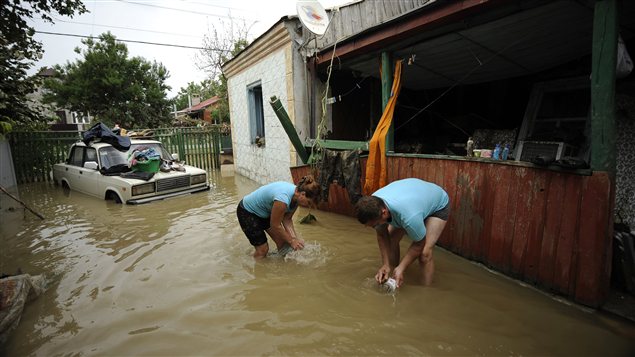 Des résidents de Krymsk fouillent les débris près d'une maison inondée