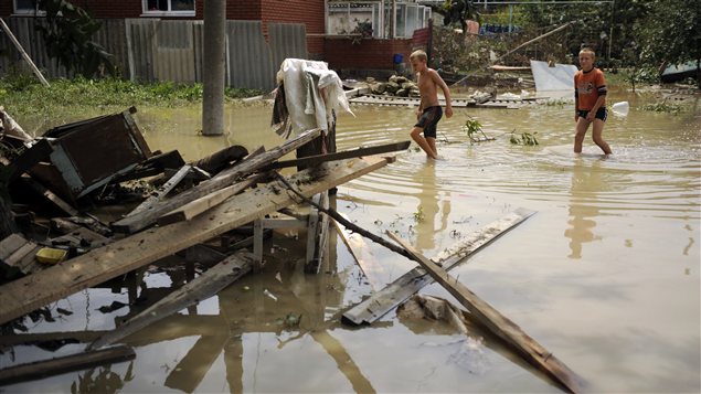 Des enfants parcourent une rue inondée de Krymsk.