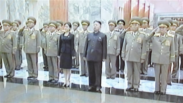 Une femme accompagne le chef d'État Kim Jong-un au palais Kumsusan de Pyongyang pour rendre hommage au défunt grand-père de ce dernier, Kim Il-sung.