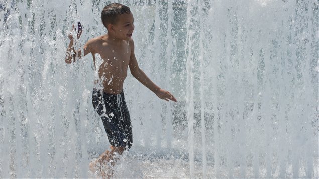 Un garçon se rafraîchit dans une fontaine, à Washington.