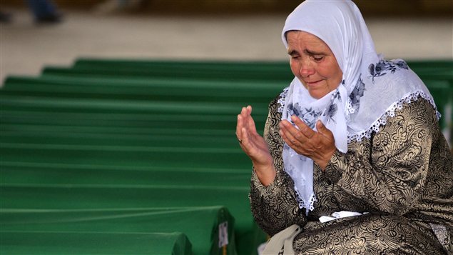 Une femme se recueille devant les 520 cercueils de victimes du massacre de Srebrenica, avant qu'ils ne soient enterrés au centre mémorial de Potocari.