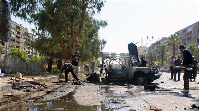 Photo de l'Agence de nouvelles officielle de la Syrie montrant les restants de l'explosion d'une voiture à Damas, le 13 juillet.