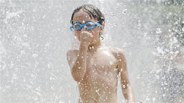Un jeune se rafraîchit dans une fontaine du Parc Westmount, dans l'île de Montréal, le 15 juillet 2010.