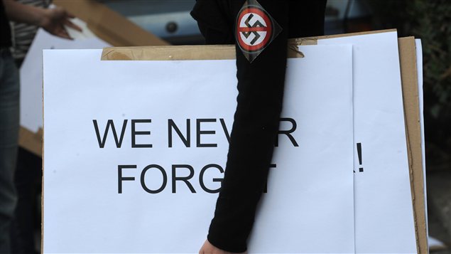 Un manifestant portant le symbole nazi près de la dernière demeure connue de Laszlo Csatary à Budapest