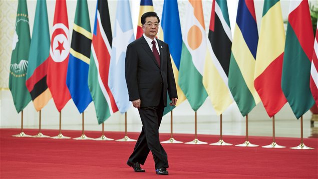 Le président chinois Hu Jintao, en train de marcher devant des drapeaux de pays africains.