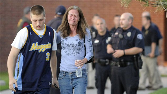 Jacob Stevens, 18 ans, témoin de la fusillade, et sa mère, Tammi, se réconfortent, après avoir été interrogés par les policiers, à Aurora.