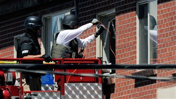 Les policiers tentent de neutraliser ce qui peut être dangereux dans l'appartement du suspect, samedi après-midi le 21 juillet 2012. 