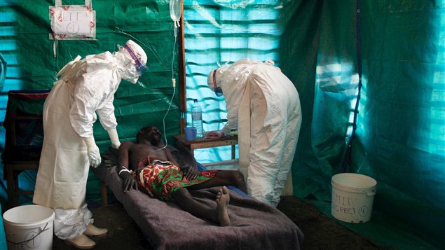 Un malade est traité par du personnel médical en combinaison dans un village du Congo. (archives)