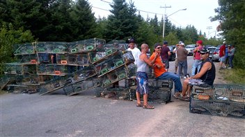 Les manifestants ont barré l'accès à l'usine Village Bay avec leurs cages de homards à Bedec, au Nouveau-Brunswick.