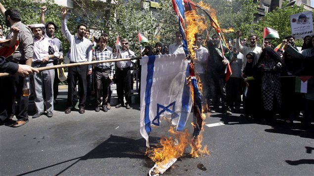 Des manifestants iraniens brûlent des drapeaux israélien et britannique.
