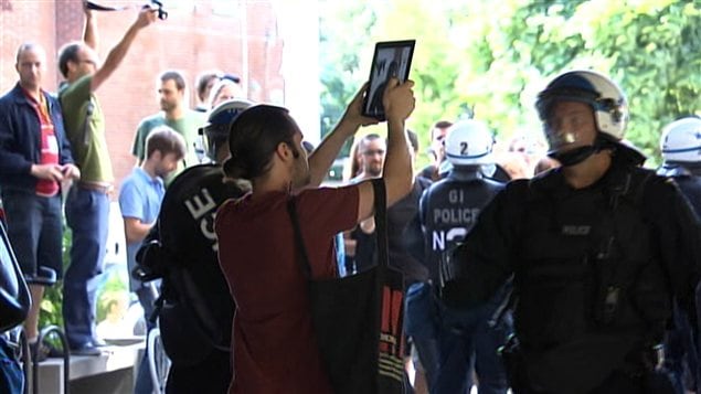 Un étudiant qui prend des photos des policiers sur le point d'être interpellé.