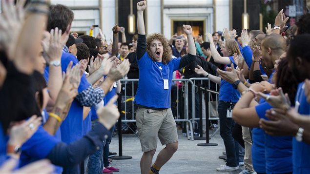 Un employé du magasin Apple de la 5e avenue, à New York, motive ses confrères de travail, alors que des centaines de personnes font la queue afin de mettre la main sur le nouvel Iphone.