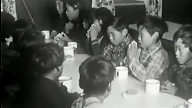 Des élèves d’un pensionnat autochtone au Canada font une prière avant leur repas.