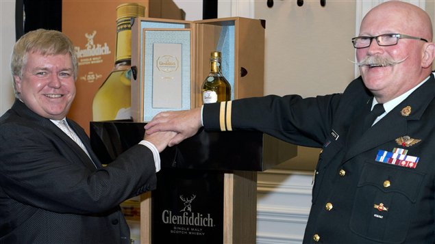 Wayne Johnston (à droite), le fondateur de Wounded Warriors, au moment de la vente de la bouteille de Glenfiddich.