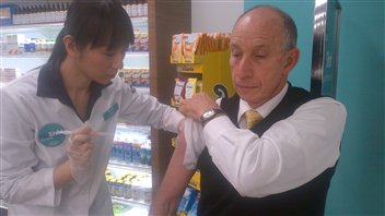 Un Torontois se fait vacciner contre la grippe dans une pharmacie.