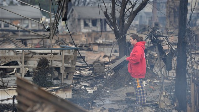 Une femme contemple les débris de sa maison rasée par les flammes qui ont détruit plus de 80 maisons dans le quartier de Queens, à New York.