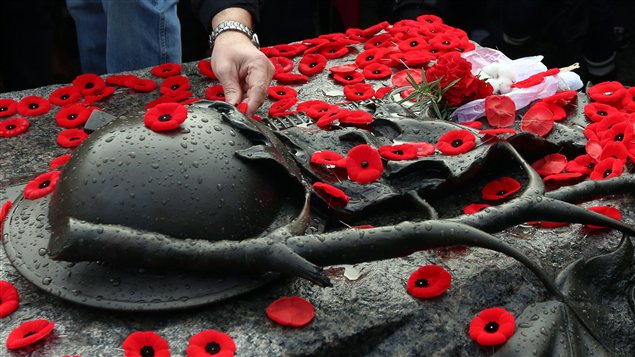 Des Canadiens déposent leur coquelicot sur la tombe du soldat inconnu à Ottawa.
