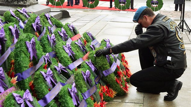 À Ottawa, un vétéran dépose, ému, une couronne en mémoire de soldats disparus.