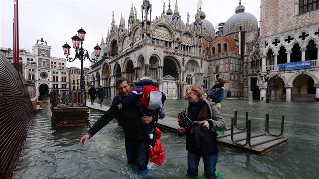 Des passants dans une rue inondée de Venise.