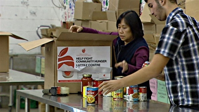 Les bénévoles à la banque alimentaire d'Ottawa préparent de nombreuses boîtes pour répondre à la demande.