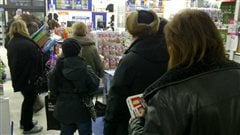 Des clients font la queue à la caisse du magasin de  jouet Toys R Us à Winnipeg vendredi matin.