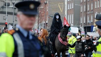 Des Irlandais manifestent contre le budget d'austérité, sous l'oeil des policiers