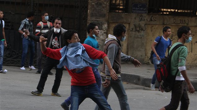 Des manifestants égyptiens lancent des pierres en direction de la police, à la place Tahrir, au Caire.