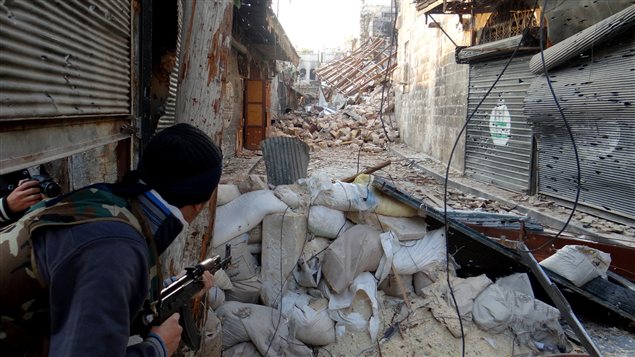 Un insurgé tient une position dans une ruelle d'Alep.
