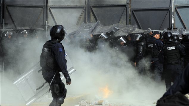 Des policiers antiémeute tentent d'empêcher des manifestants de mettre à terre une clôture de sécurité à l'extérieur du Parlement lors de l'assermentation du président.