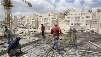 Des travailleurs érigent un complexe d'habitation à Jérusalem-Est.
