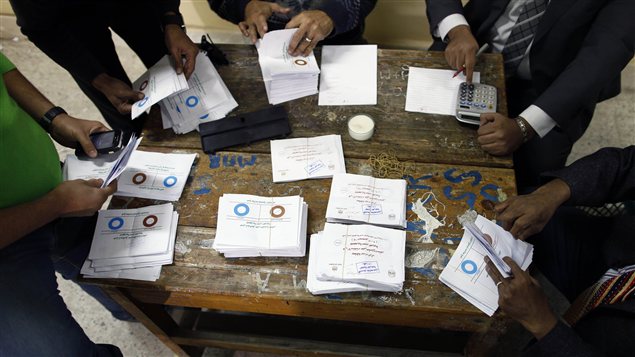 Des officiels procèdent au décompte des bulletins de vote, après le premier jour de vote sur le projet de Constitution en Égypte.