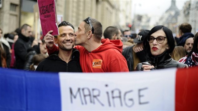 Un homme embrasse son compagnon durant la manifestation pour le projet de loi permettant le mariage et l'adoption pour les gais, à Paris.