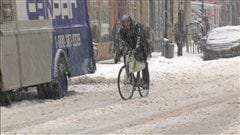 Un cycliste roule dans la neige dans une rue de Montr�al