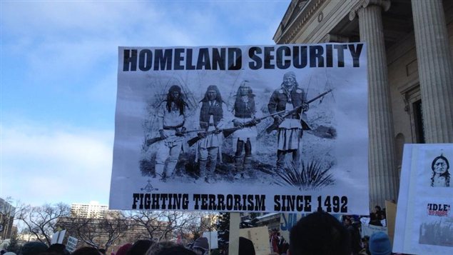 Des manifestants exhibent divers messages lors d'un rassemblement devant le palais législatif du Manitoba, le 21 décembre 2012.