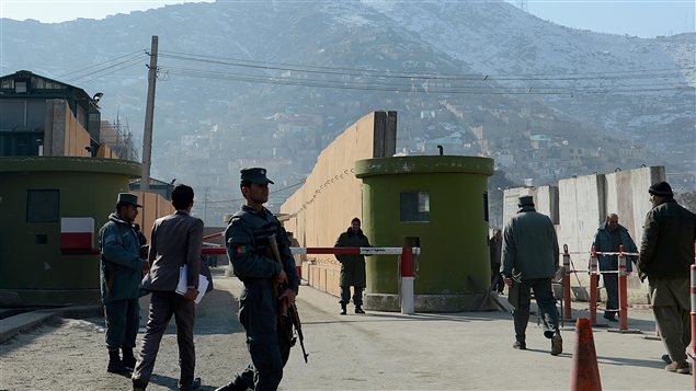 Des membres des forces de sécurité montent la garde devant le quartier général de la police à Kaboul, où un consultant a été abattu par une policière afghane