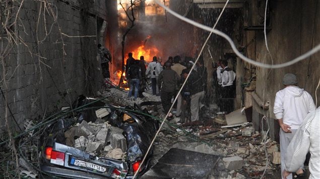 Des Syriens inspectent la scène d'une explosion à Jaramana le 28 novembre 2012.