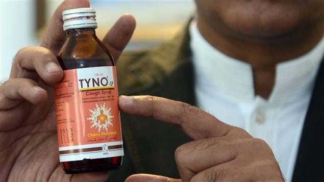 Un officiel pakistan montre le sirop contre la toux qui serait en cause dans la mort de 33 personnes