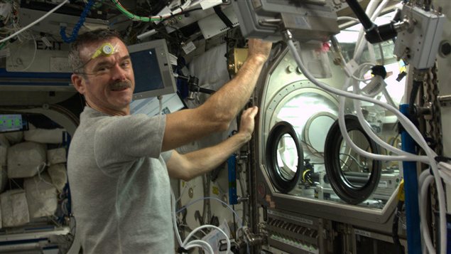 L'astronaute Chris Hadfield effectuant une expérience dans la Station spatiale internationale.