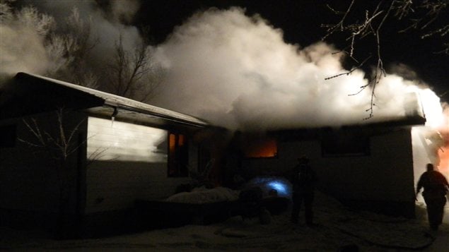 Des pompiers combattent un incendie dans une résidence de Gimli au Manitoba, tôt le matin du 1er janvier 2013.