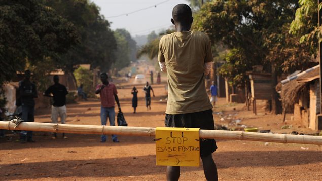 Un homme bloque une route menant à la capitale en prévision d'une éventuelle offensive des rebelles à Bangui.