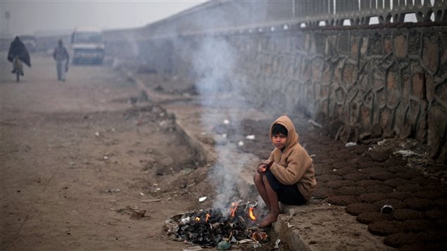 Un garçon tente de se garder au chaud à New Delhi, en Inde, une région qui fait face à une vague de froid d'une rare intensité