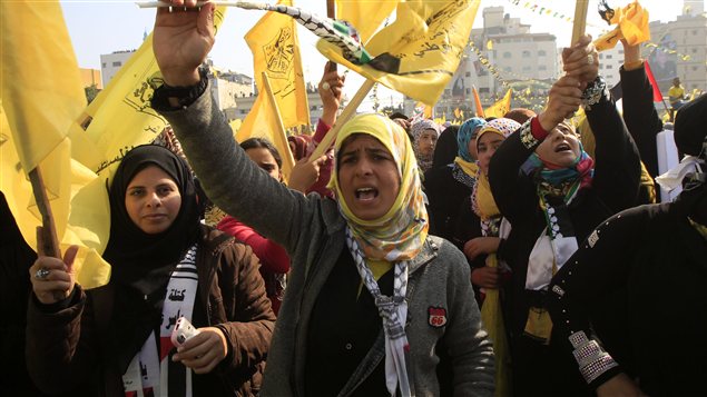 Des jeunes femmes agitent les drapeaux jaunes du Fatah lors d'une manifestation à Gaza pour fêter l'anniversaire du mouvement du président Mahmoud Abbas, le 4 janvier 2013.