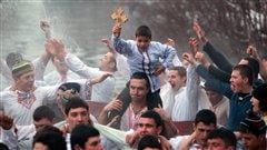 Des Bulgares chantent et dansent dans la rivière Tundzha, à Kalofer.