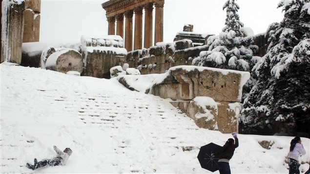 Des enfants s'amusent dans la neige au pied du temple romain de Jupiter, à Baalbek, au Liban.