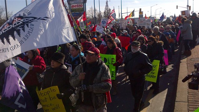 Des manifestants marchent le long du chemin Huron Church à Windsor.