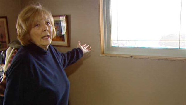 Lydia Grubert montrant une fenêtre dont l'installation est inachevée dans sa maison de Twin Lakes Beach endommagée par les inondations de 2011.
