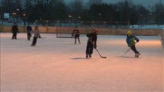 Des enfants jouent sur une patinoire.