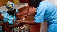 Une travailleuse traite un jeune enfant.