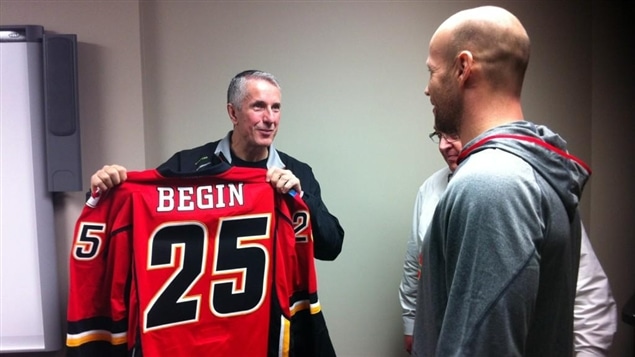 Steve Bégin reçoit son chandail des mains de l'entraîneur-chef des Flames, Bob Hartley.