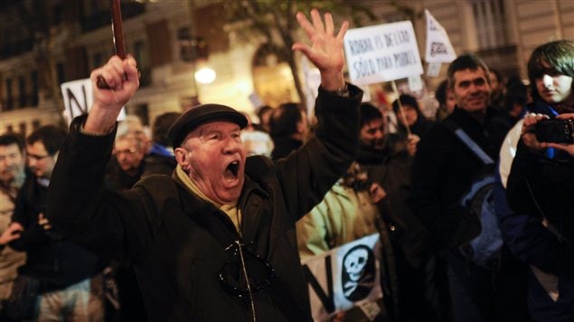 Des manifestants protestent contre les allégations de corruption devant le siège du Parti populaire, à Madrid